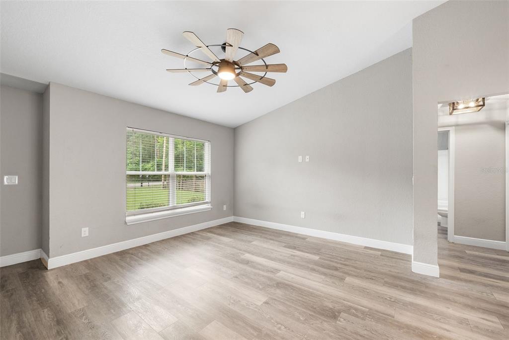 An empty room with light gray walls, wood-look flooring, and a modern ceiling fan — 6771 CHERRY ROAD, OCALA, FL