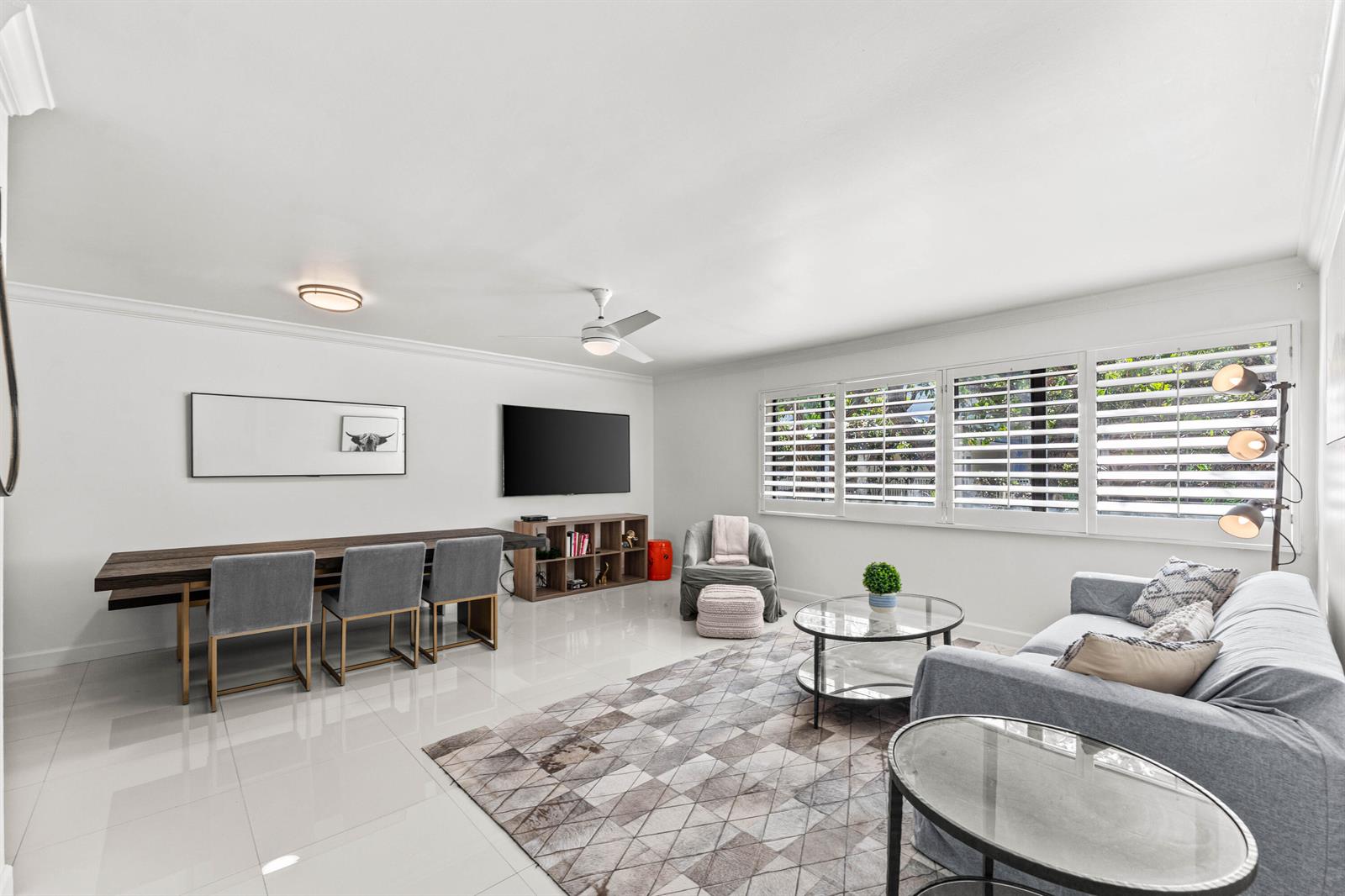 A living and dining area features white tile floors, a gray sofa, and a long table — 250 S Ocean Boulevard # 269, Delray Beach FL 33483, DELRAY BEACH, FL