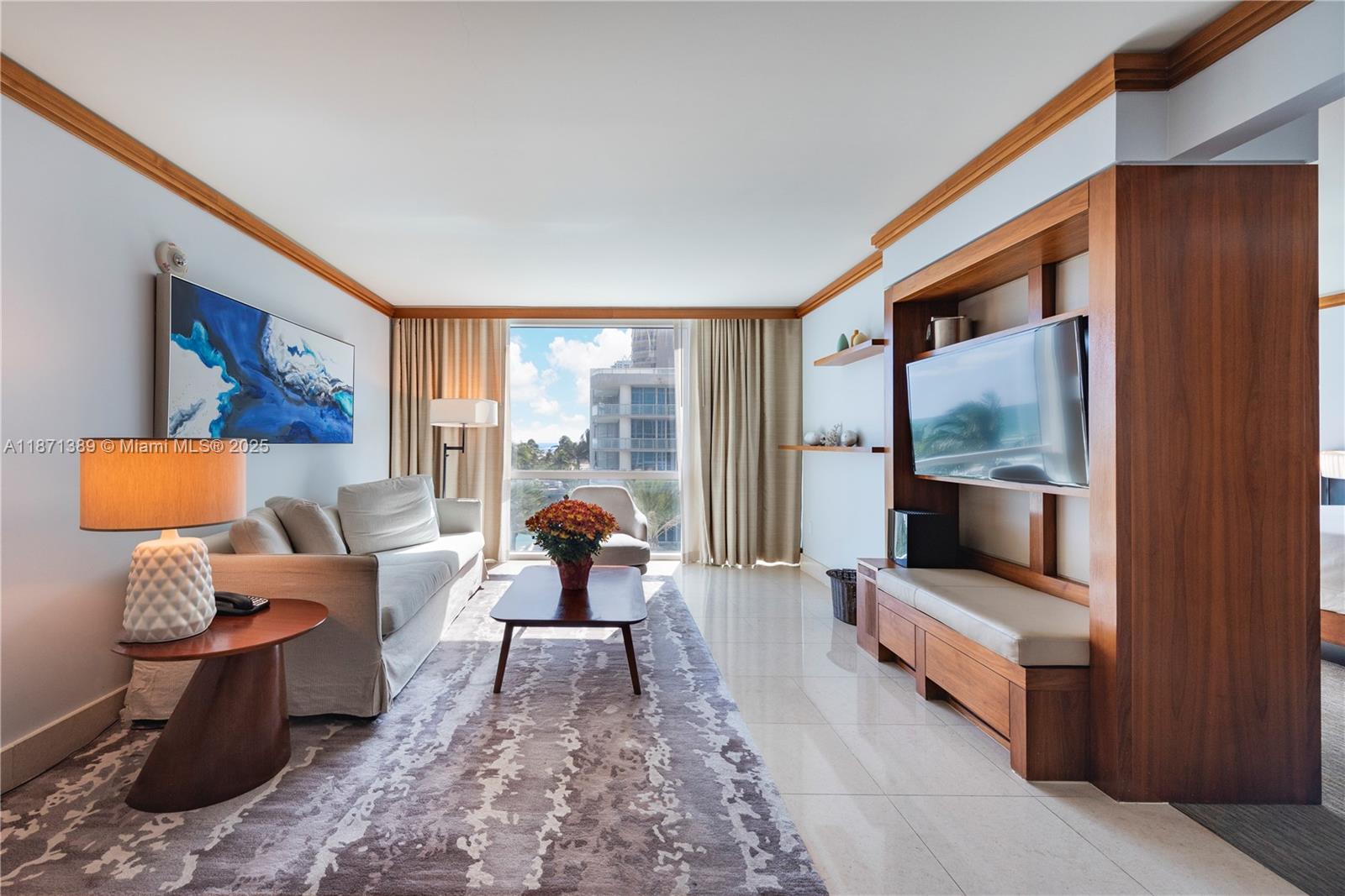 A living room features a sofa, coffee table, area rug, and a built-in media unit — 6801 Collins Ave, Miami Beach FL 33141, MIAMI BEACH, FL