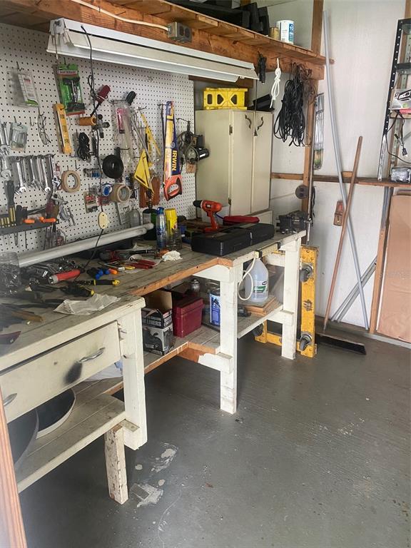 A workshop area features a wooden workbench with a pegboard wall and various hand tools — 38210 WILLIAMS AIRE STREET, DADE CITY, FL