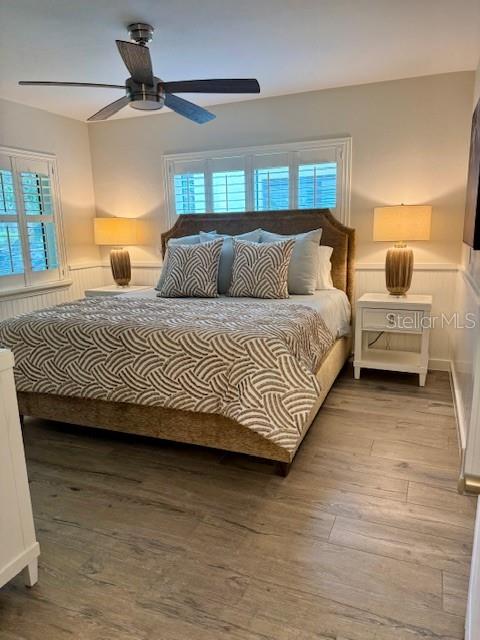 A bedroom features a bed with a patterned comforter, two nightstands, and a ceiling fan — 1637 SE PARADISE CIRCLE UNIT 205, CRYSTAL RIVER, FL