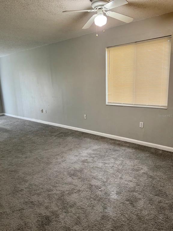 An empty room with gray carpet, gray walls, a ceiling fan, and a window — 105 CORY LANE, WINTER SPRINGS, FL