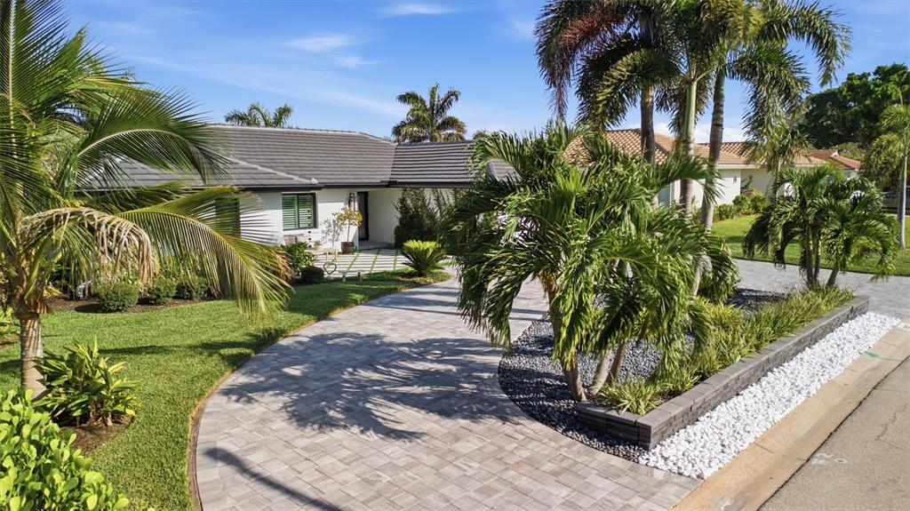 A single-story house with a paved driveway, palm trees, and a landscaped front yard — 2022 HAWAII AVENUE NE, ST PETERSBURG, FL