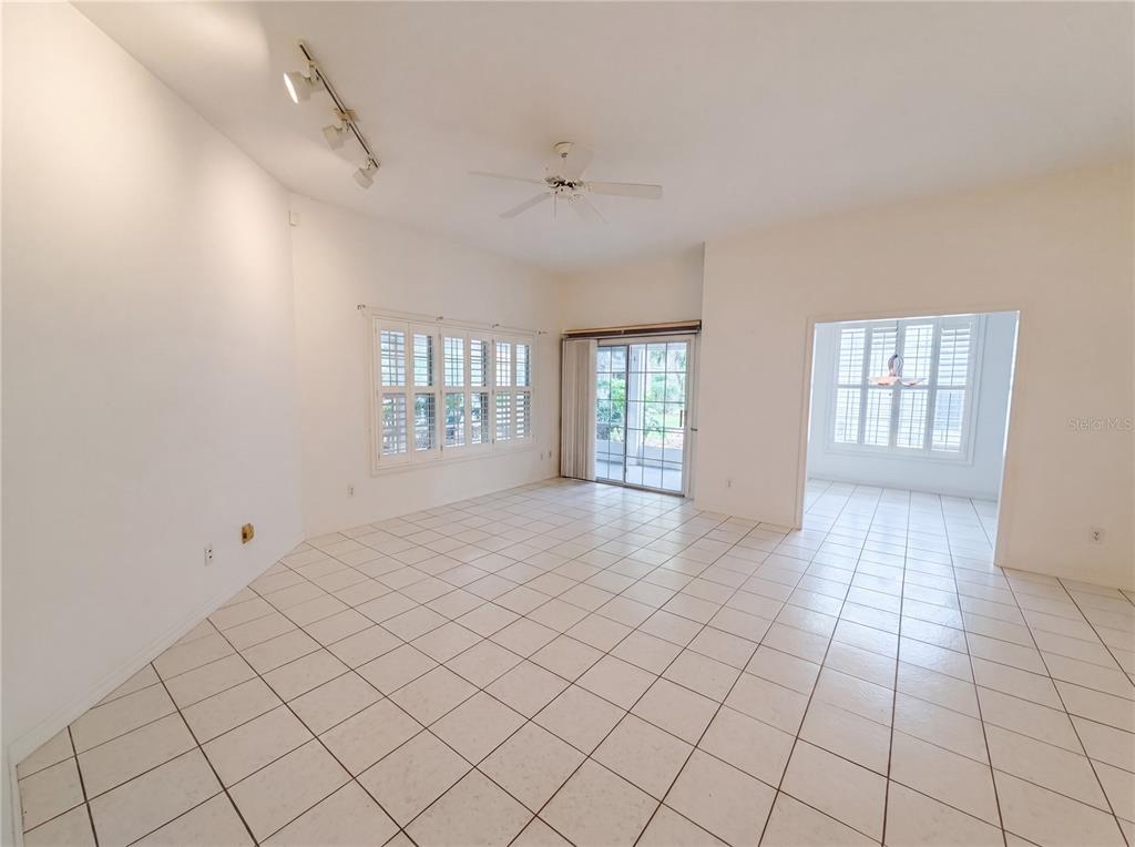 An empty room with white tile floors, a ceiling fan, and sliding glass doors — 3319 NEWBLISS CIRCLE, ORMOND BEACH, FL
