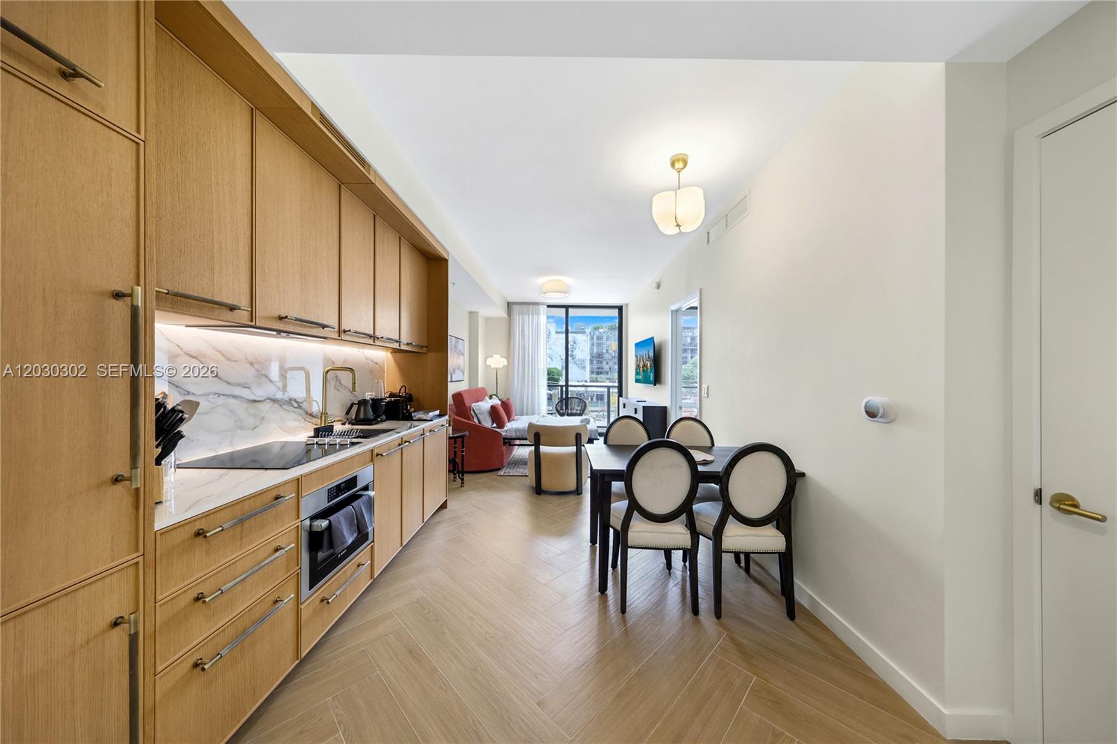 A kitchen with light wood cabinetry and a dining area with four chairs — 2700 NW 2nd Ave # 218, Miami FL 33127, MIAMI, FL