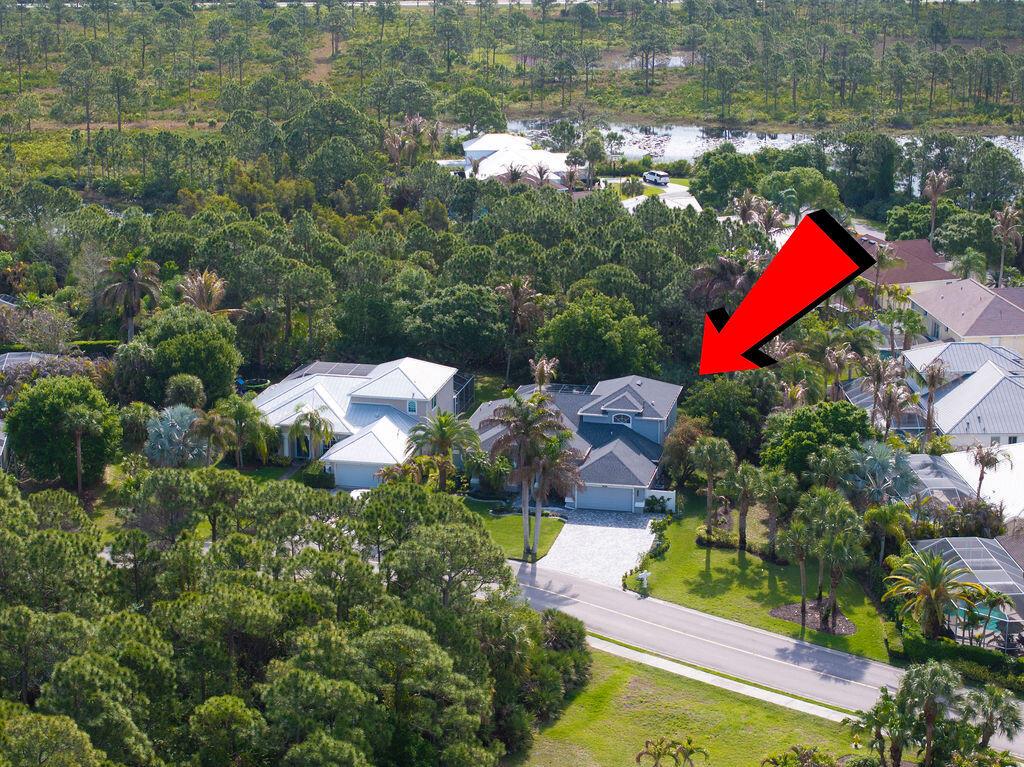 An aerial view shows a residential house with a gray roof surrounded by lush trees — 2981 NW Windemere Drive, Jensen Beach FL 34957, JENSEN BEACH, FL
