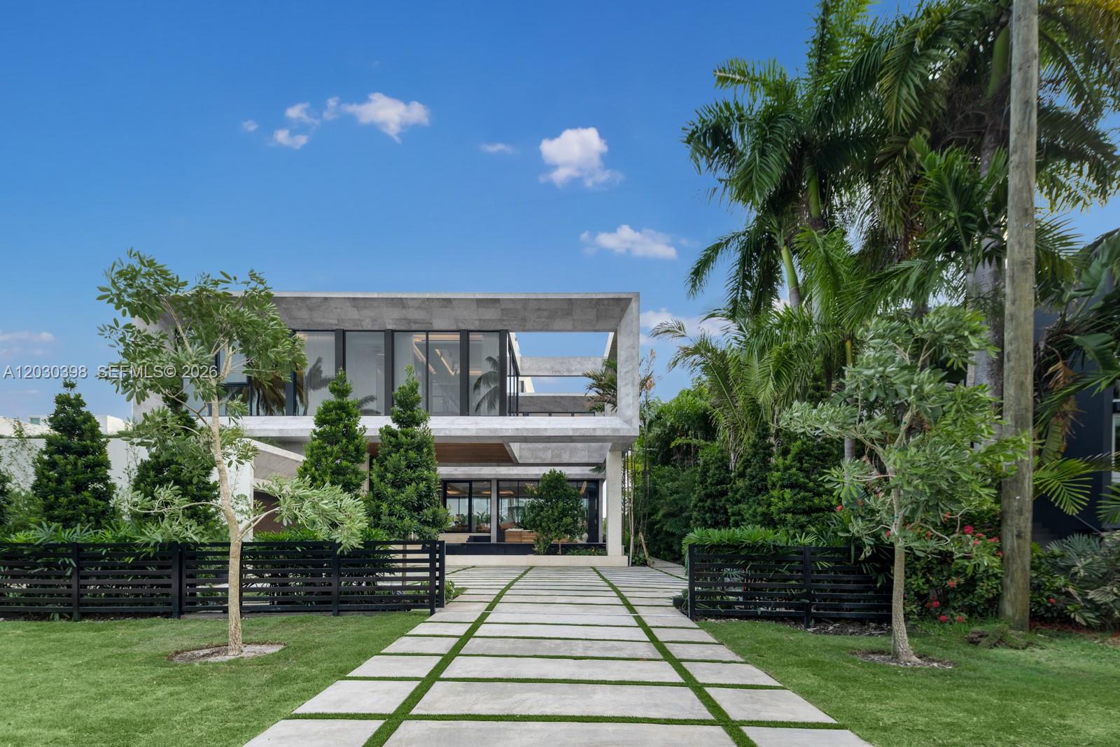 A modern two-story concrete house features a paved driveway and lush landscaping — 360 S Hibiscus Drive, Miami Beach FL 33139, MIAMI BEACH, FL