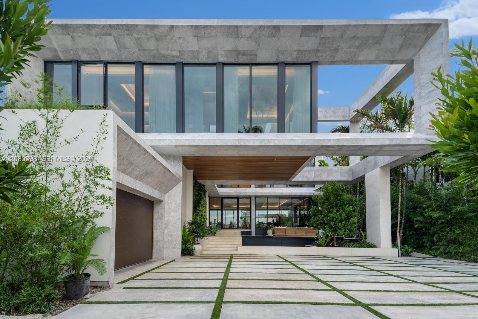 A modern two-story home features a stone facade, large glass windows, and a paved driveway — 360 S Hibiscus Drive, Miami Beach FL 33139, MIAMI BEACH, FL