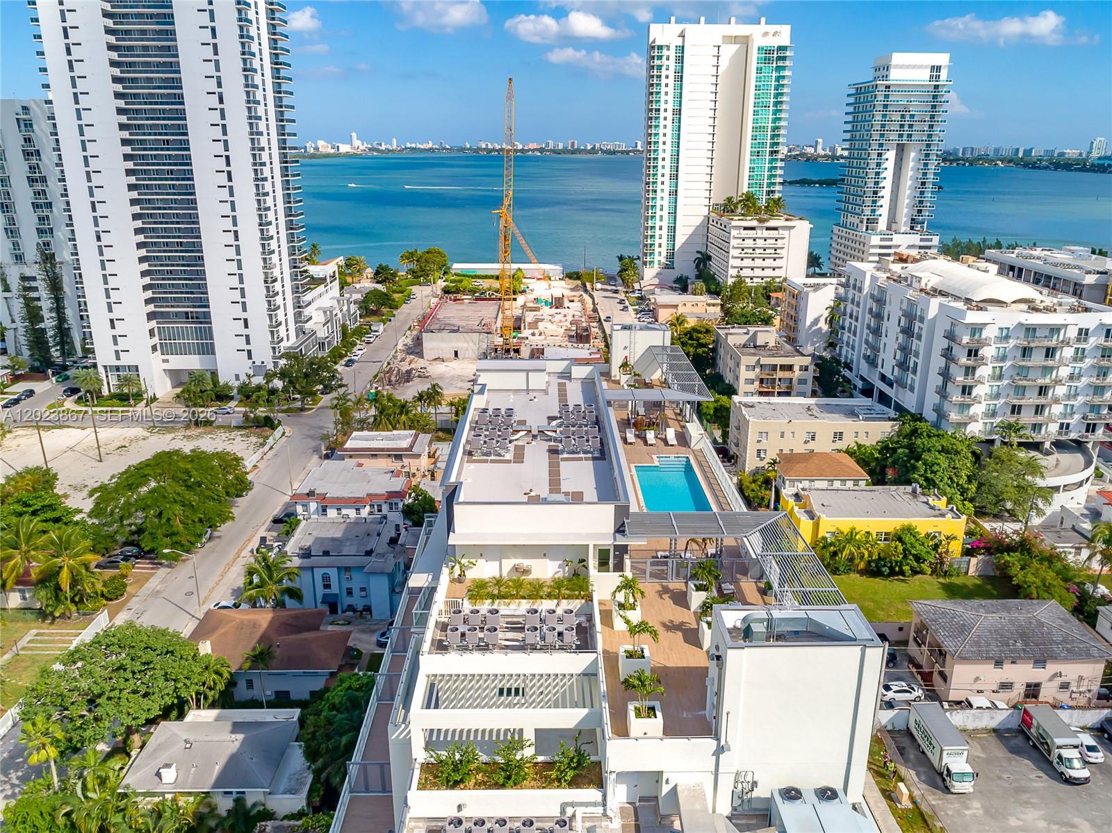 An aerial view shows a modern apartment building with a rooftop pool and surrounding neighborhood — 321 NE 26th St # 604, Miami FL 33137, MIAMI, FL