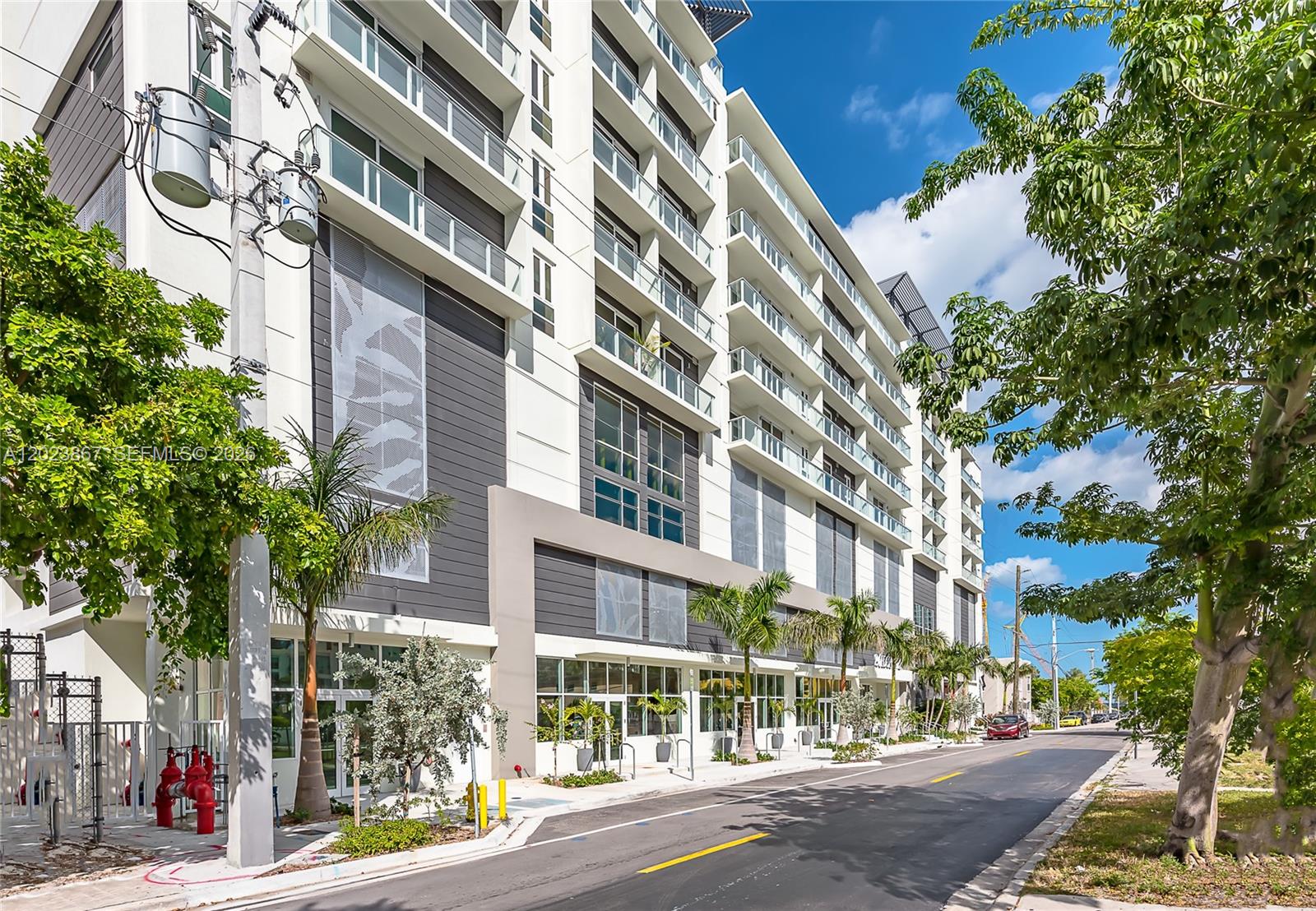 A modern multi-story apartment building with glass balconies stands beside a paved street — 321 NE 26th St # 604, Miami FL 33137, MIAMI, FL