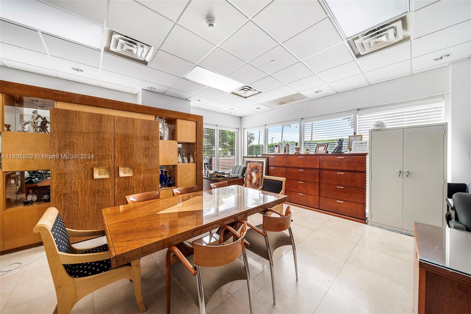 An office features a wooden conference table, matching storage cabinets, and a drop ceiling — 2101 Brickell Ave, Miami FL 33129, MIAMI, FL