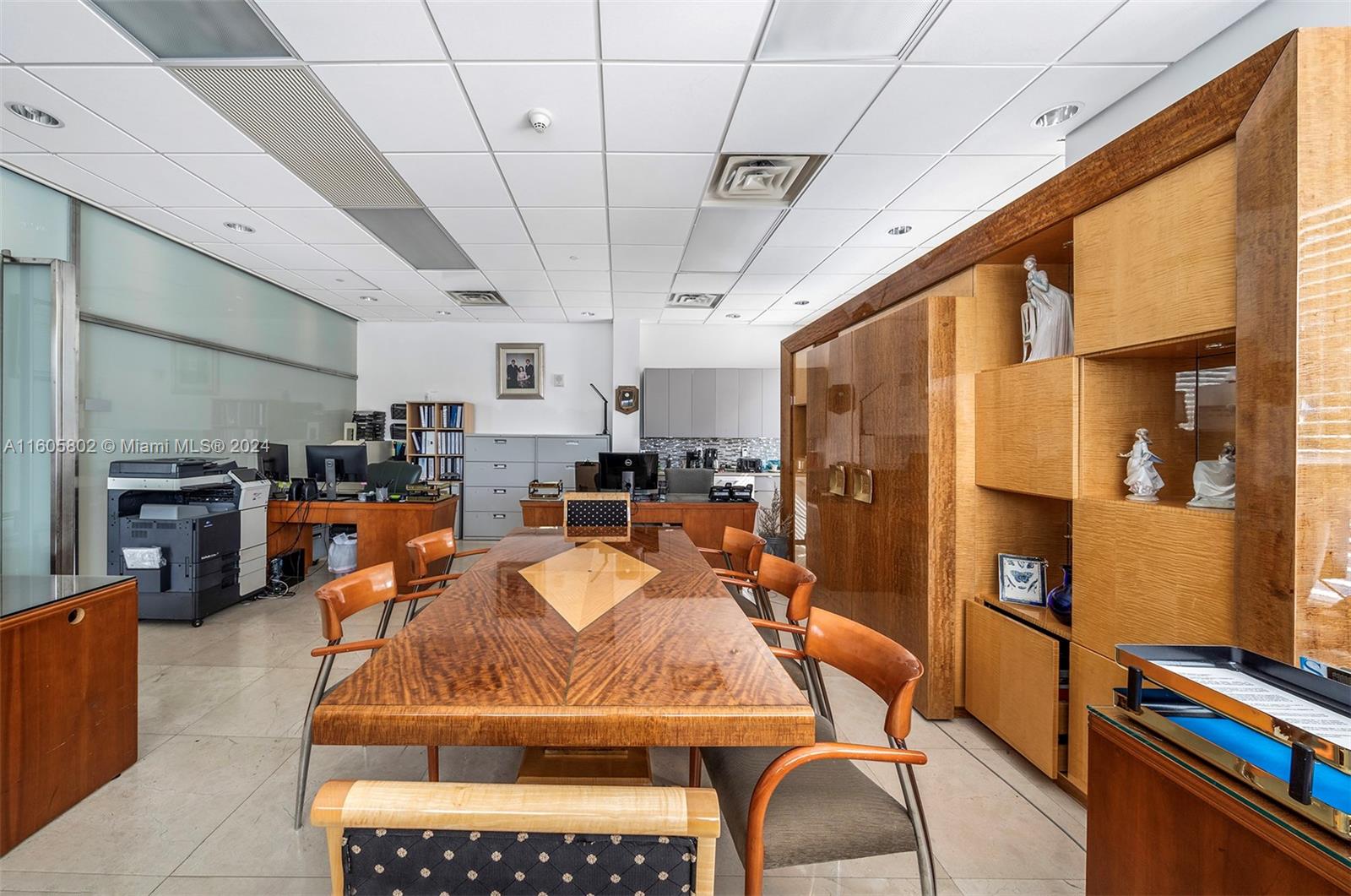 An office space features a large wooden conference table, chairs, and built-in display shelving — 2101 Brickell Ave, Miami FL 33129, MIAMI, FL