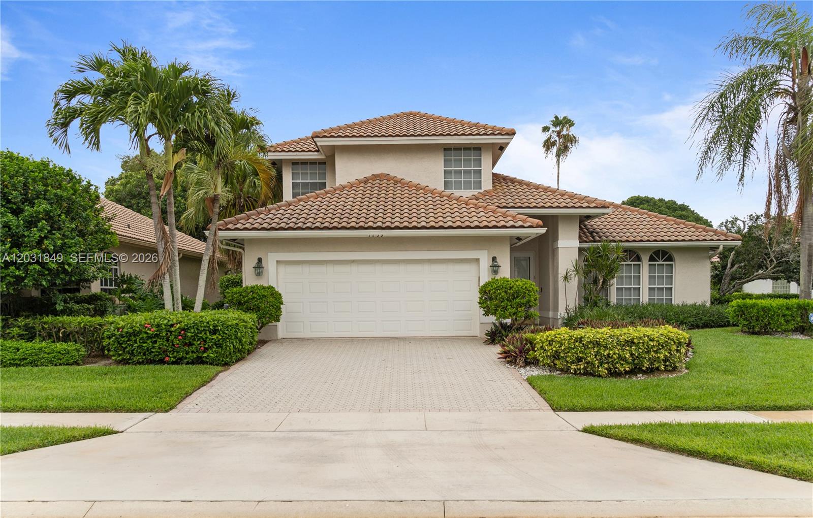 A two-story suburban house features a tiled roof, a two-car garage, and landscaped front gardens — 7759 La Corniche Cir, Boca Raton FL 33433, BOCA RATON, FL