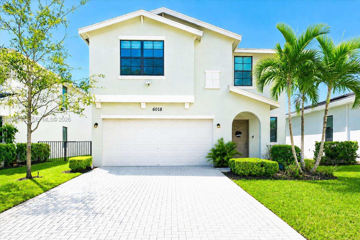 A two-story house with a white stucco facade, a two-car garage, and palm trees — 6018 Henderson Way, West Palm Beach FL 33415, WEST PALM BEACH, FL