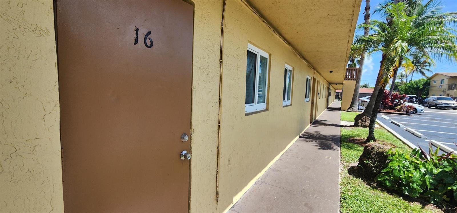A yellow exterior wall features a door labeled 16, several windows, and a concrete walkway — 620 NW 7th Avenue # 16, Pompano Beach FL 33060, POMPANO BEACH, FL