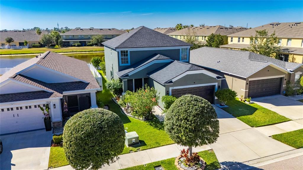 An aerial view shows a two-story house with a gray exterior and a shingled roof — 1504 TRAILWATER STREET, RUSKIN, FL