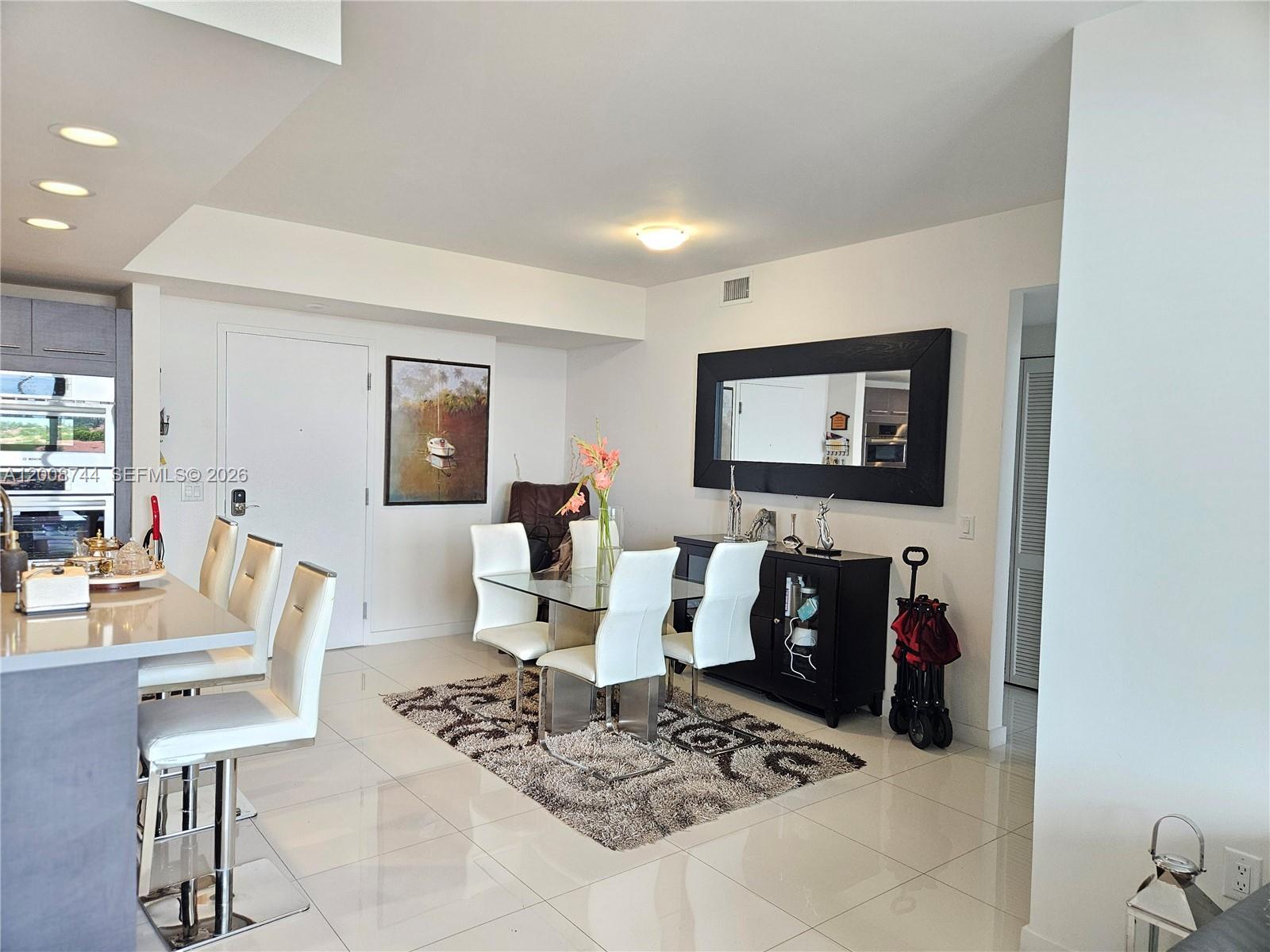 A dining area features a glass table, white chairs, a black sideboard, and tiled floors — 7875 NW 107th Ave # 510, Doral FL 33178, DORAL, FL