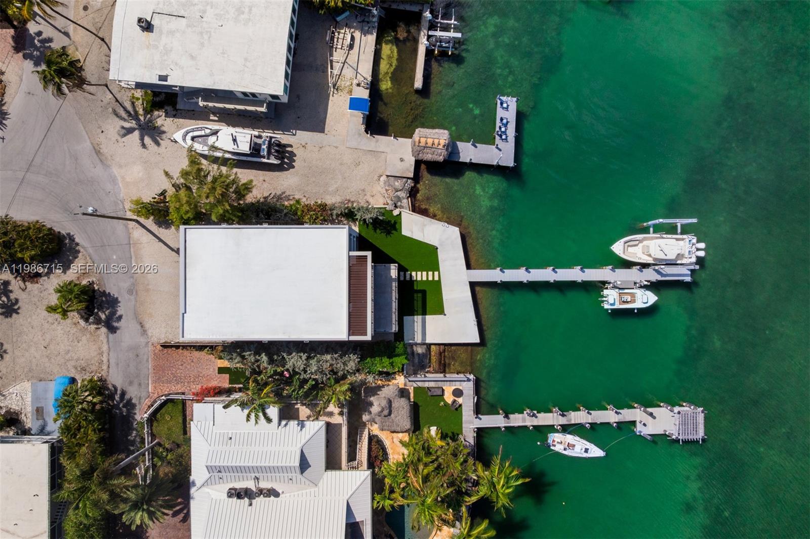 An aerial view shows waterfront properties with private docks, boats, and lush landscaping — 21 Stillwright Way, Key Largo FL 33037, KEY LARGO, FL