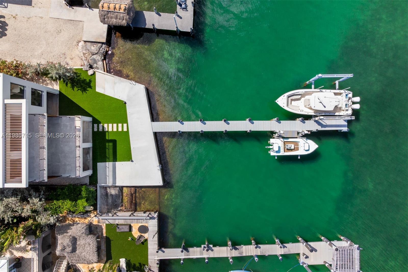 An aerial view shows a modern house with a dock, two boats, and artificial turf — 21 Stillwright Way, Key Largo FL 33037, KEY LARGO, FL