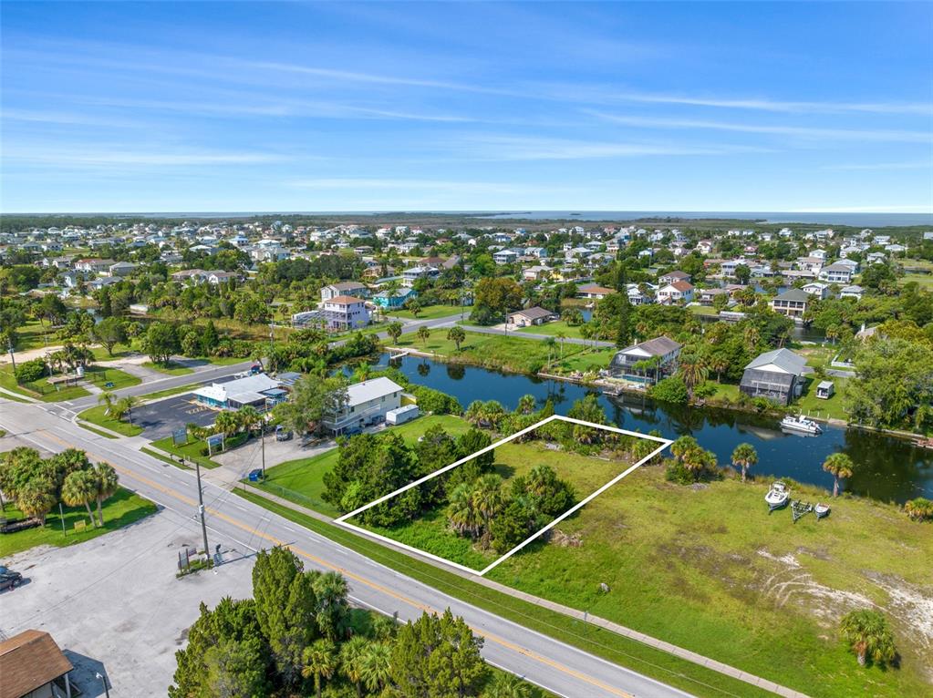 An aerial view shows a vacant, rectangular lot outlined in white next to a canal — 3329 SHOAL LINE BOULEVARD, HERNANDO BEACH, FL