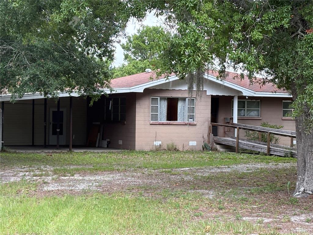 A single-story house with a carport, a wooden wheelchair ramp, and a reddish roof — 231 BOY SCOUT ROAD, LAKE WALES, FL