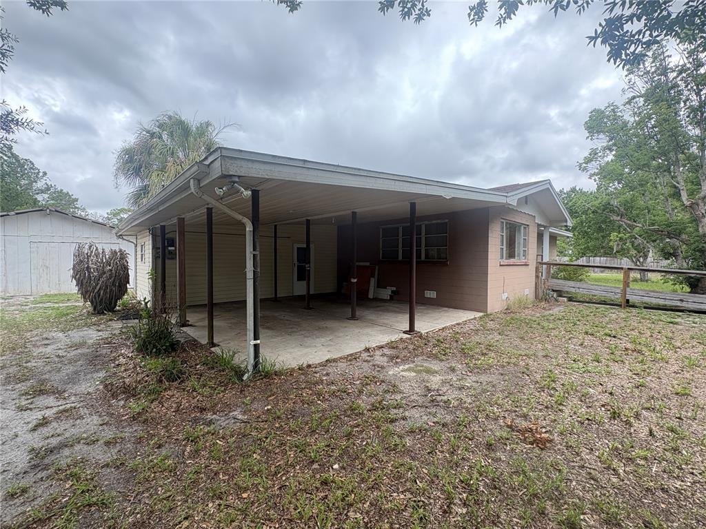 A side view of a house featuring a large covered carport and a detached shed — 231 BOY SCOUT ROAD, LAKE WALES, FL