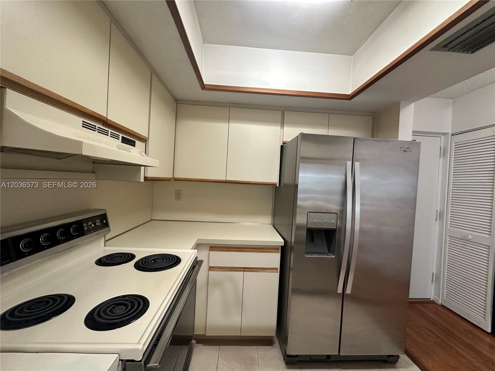 A kitchen features white cabinets, a white electric stove, and a stainless steel refrigerator — 8999 SW 123rd Ct # 212, Miami FL 33186, MIAMI, FL