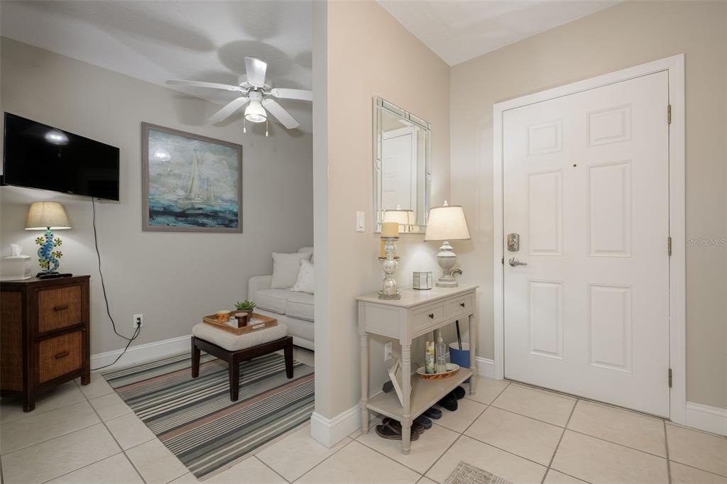 An entryway with a console table and mirror leads into a small living area — 4650 LINKS VILLAGE DRIVE UNIT C206, PONCE INLET, FL
