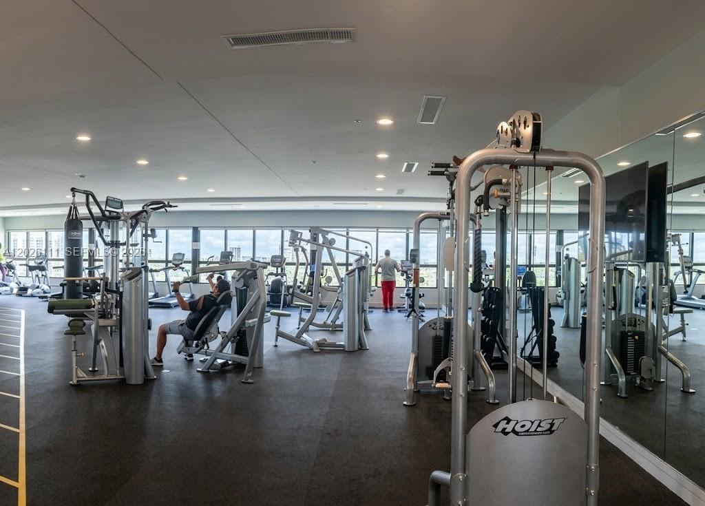 A gym with various exercise machines, large windows, and mirrored walls — 10620 NW 88th St # 221, Doral FL 33178, DORAL, FL