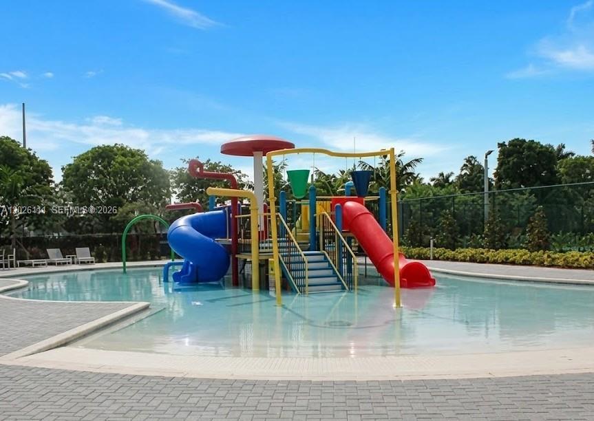 A colorful playground structure with slides sits in the center of a shallow swimming pool — 10620 NW 88th St # 221, Doral FL 33178, DORAL, FL