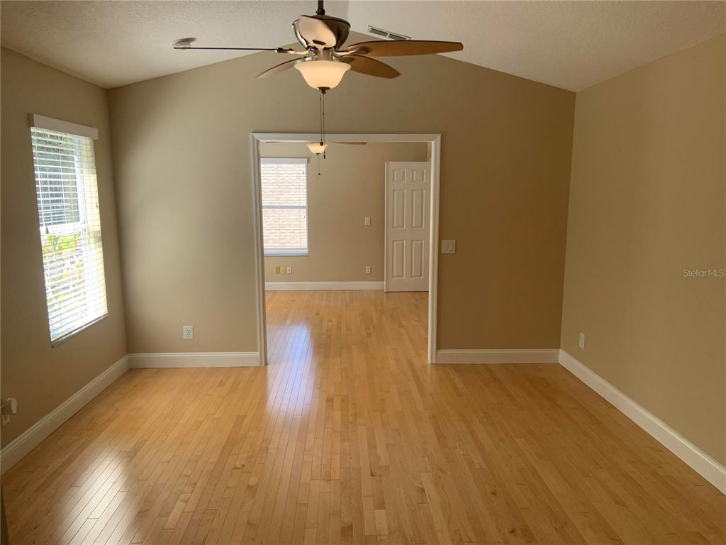 An empty room with light wood flooring, a vaulted ceiling, and a ceiling fan — 4527 RIVERTON DRIVE, ORLANDO, FL