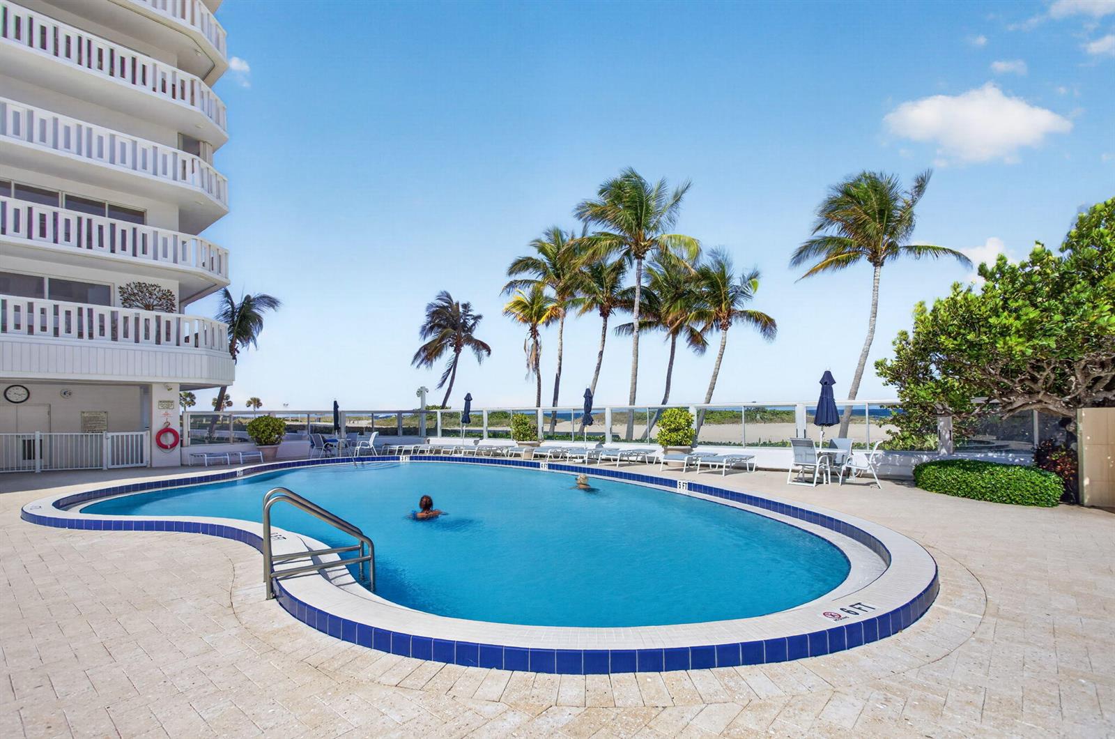 An outdoor swimming pool sits on a paved patio next to a multi-story residential building — 1012 N Ocean Boulevard # 408, Pompano Beach FL 33062, POMPANO BEACH, FL