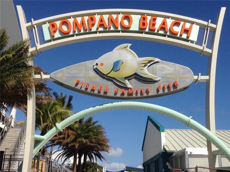 An arched sign for the Pompano Beach Fisher Family Pier features a large fish sculpture — 1012 N Ocean Boulevard # 408, Pompano Beach FL 33062, POMPANO BEACH, FL