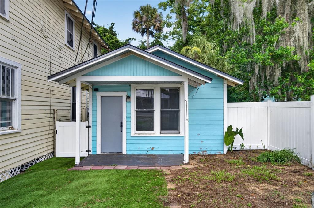 A small light blue detached structure with a front porch sits next to a house — 309 RUSH STREET, NEW SMYRNA BEACH, FL