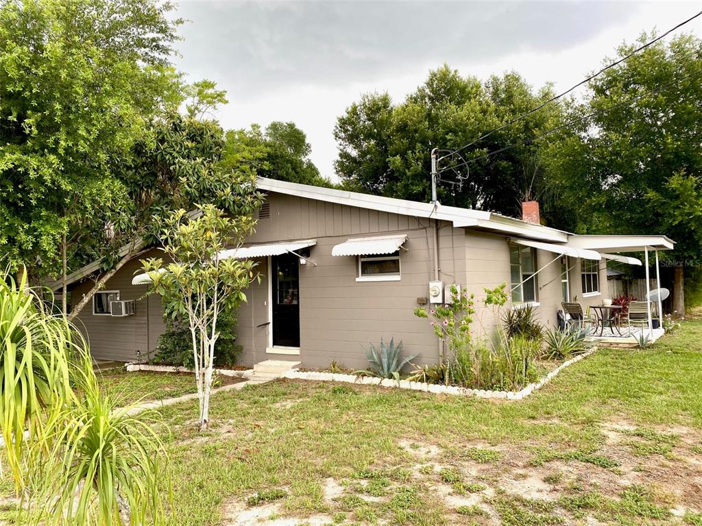 A single-story house with gray siding, a covered patio, and a grassy yard — 3801 US HIGHWAY 17 92 N, DAVENPORT, FL