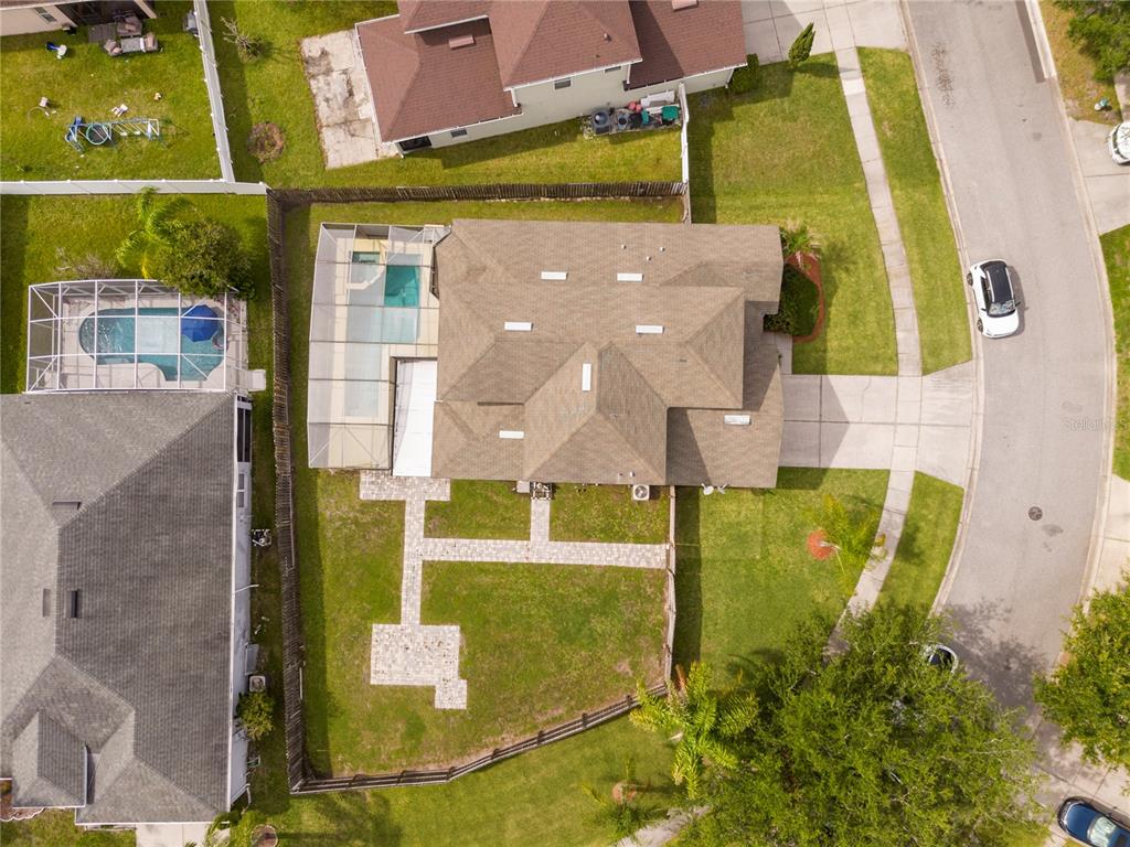 An aerial view shows a house with a screened pool and a paved backyard walkway — 1986 MARSH HAWK DRIVE, ORLANDO, FL