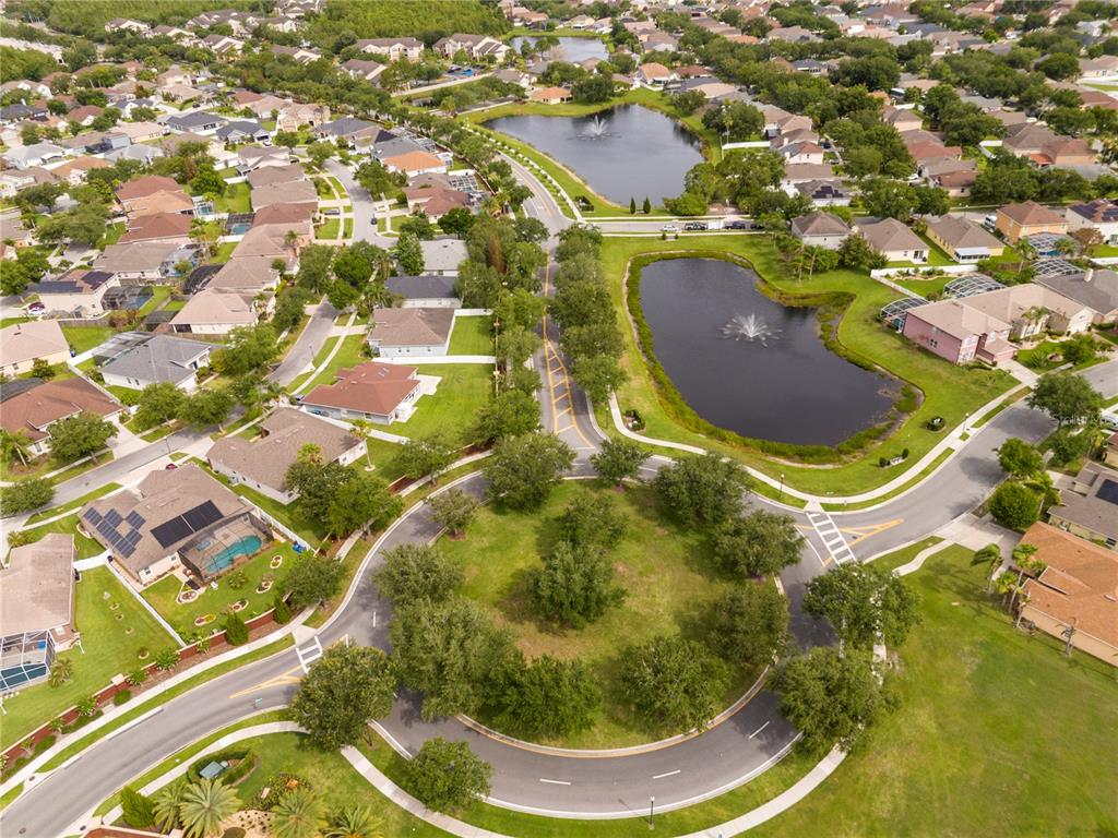An aerial view shows a suburban neighborhood with houses, a circular road, and two ponds — 1986 MARSH HAWK DRIVE, ORLANDO, FL