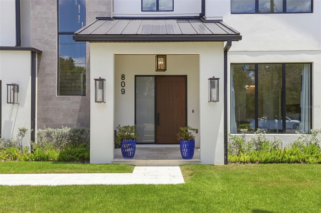 The exterior of a modern home features a covered entryway with a wood door — 809 E CHURCH STREET, ORLANDO, FL