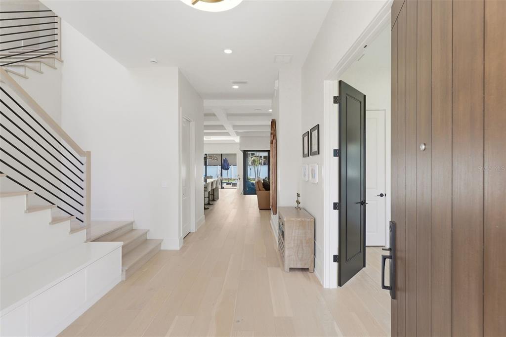 A bright entryway features light wood floors, a modern staircase, and a view toward the back — 809 E CHURCH STREET, ORLANDO, FL