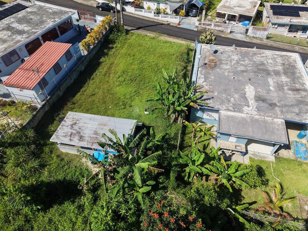 An aerial view shows a grassy lot situated between two residential buildings and a street — PR-759 (Int) CALLE 5 LOTE 269, MAUNABO, PR