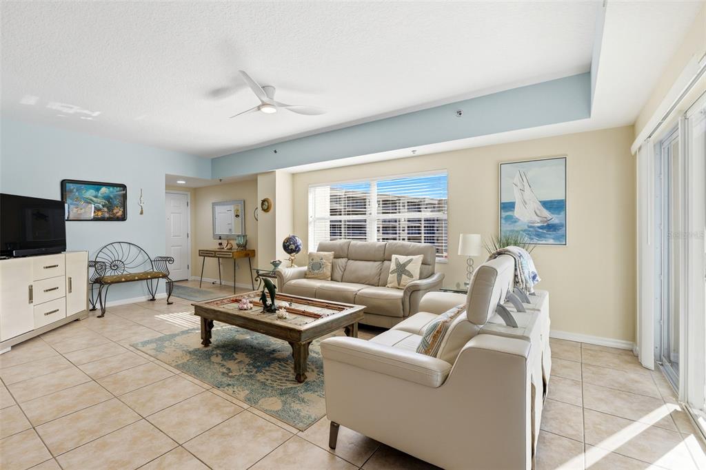 An open-concept living and dining area with tile floors, a ceiling fan, and a kitchen — 5300 S ATLANTIC AVENUE UNIT 9-401, NEW SMYRNA BEACH, FL