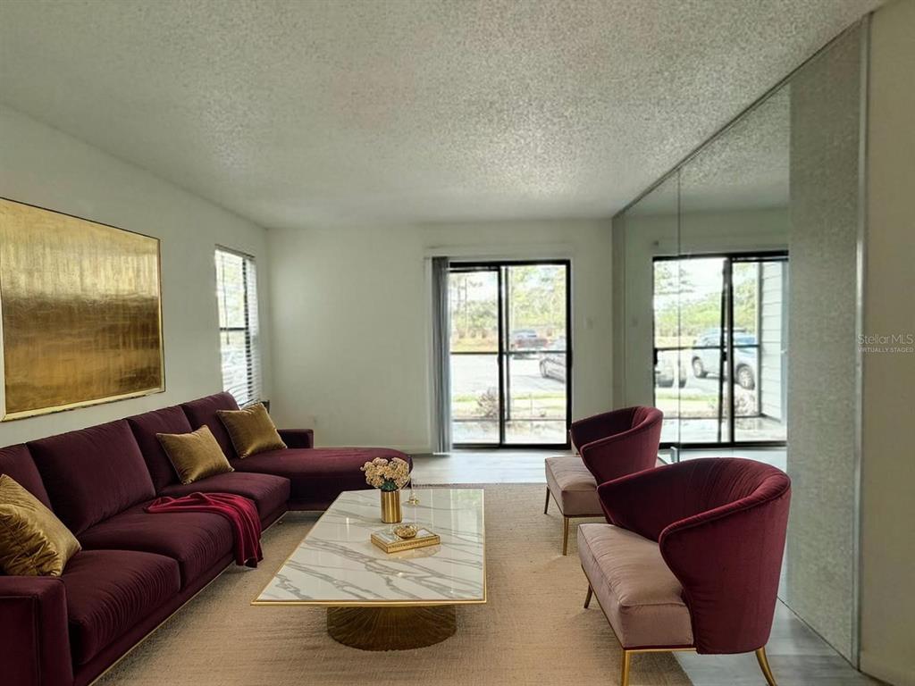 A living room features a purple sectional, two matching chairs, and a marble coffee table — 3756 IDLEBROOK CIRCLE UNIT 108, CASSELBERRY, FL