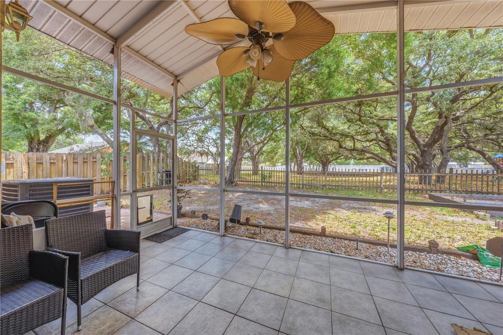 A screened-in porch with tile flooring, a ceiling fan, and a view of the backyard — 3324 MANOR COVE CIRCLE, RIVERVIEW, FL