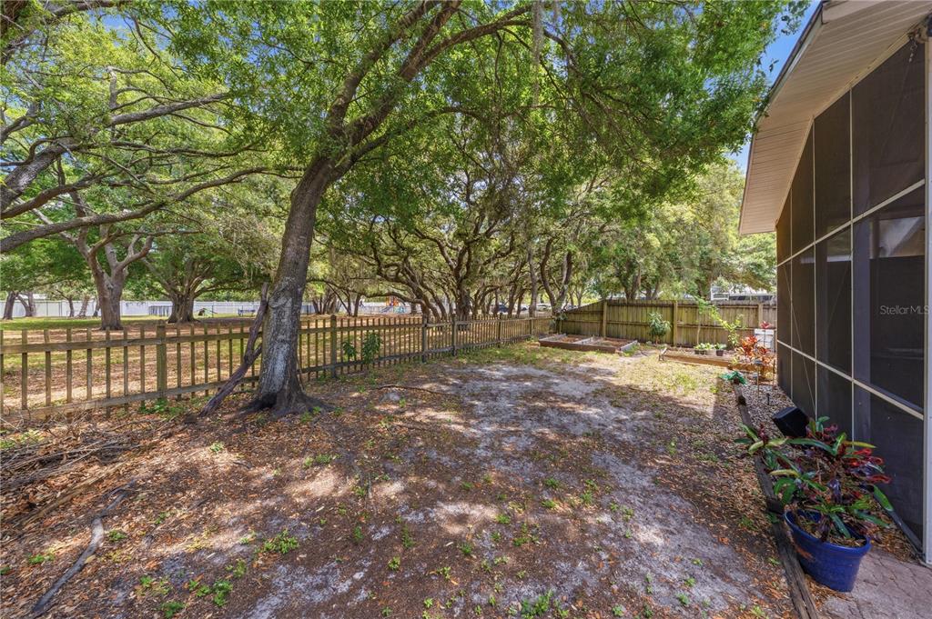 A tiled screened-in porch features a ceiling fan, a floral-patterned refrigerator, and sliding glass doors — 3324 MANOR COVE CIRCLE, RIVERVIEW, FL