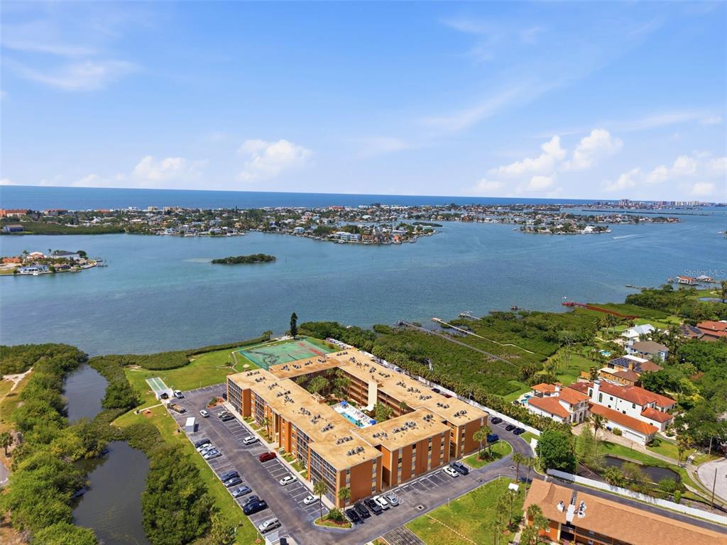 An aerial view shows a multi-story apartment complex with a central courtyard and parking lot — 12760 INDIAN ROCKS ROAD UNIT 1082, LARGO, FL