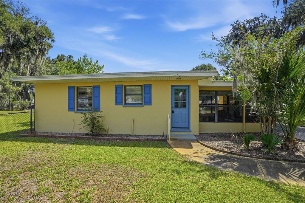 A yellow single-story house with blue shutters and a blue front door — 951 CR 453, LAKE PANASOFFKEE, FL