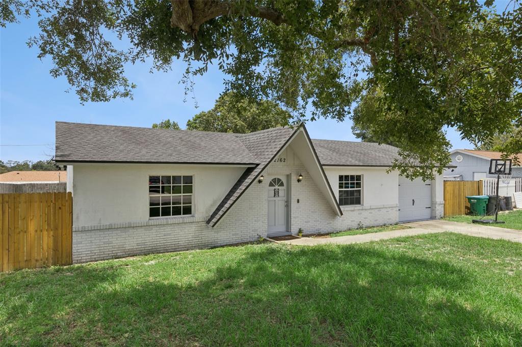 A single-story house with a white brick facade, a peaked entryway, and a garage — 2162 SWANSON DRIVE, DELTONA, FL