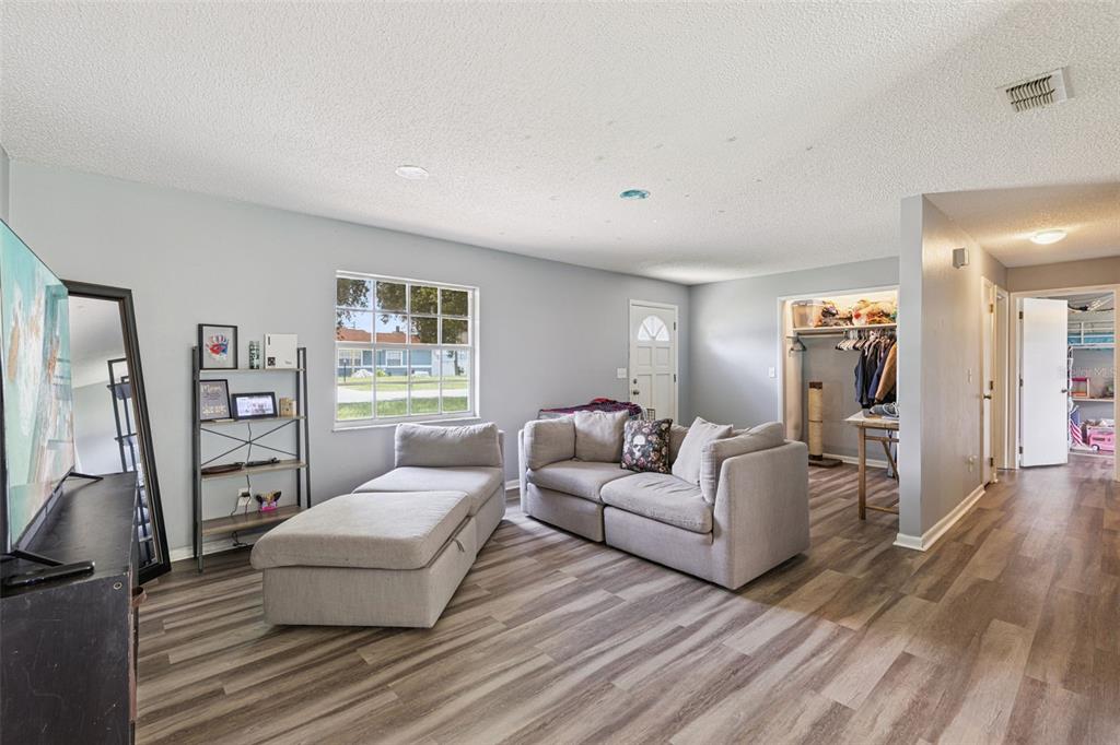 An empty room with light gray walls, wood-look flooring, and a large window — 2162 SWANSON DRIVE, DELTONA, FL