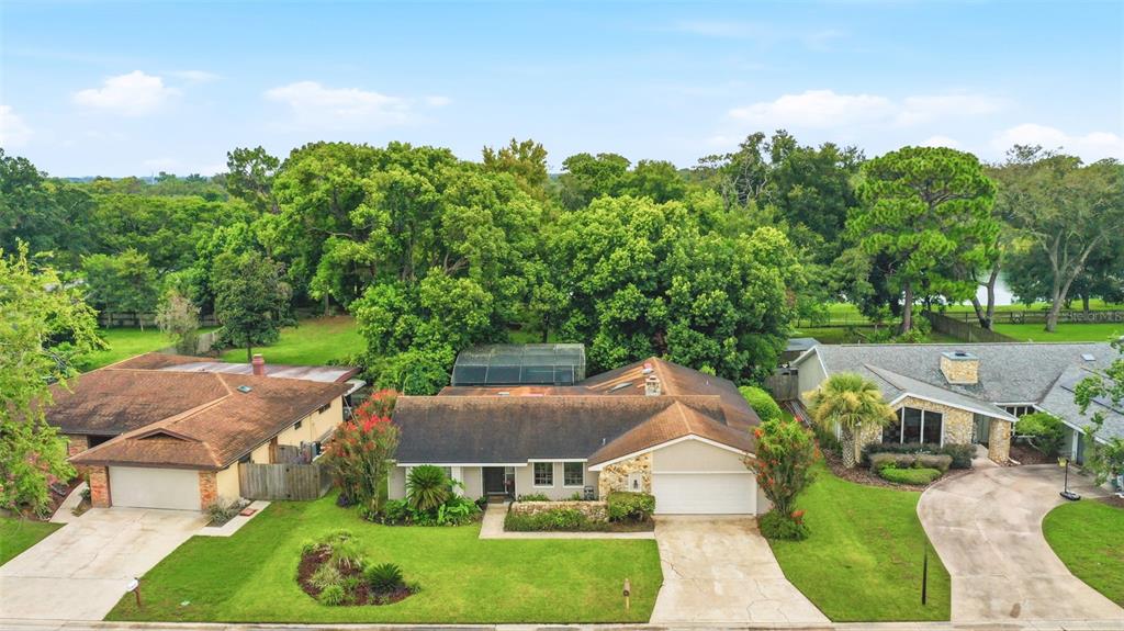 An aerial view of a suburban house with a brown roof and a front lawn — 207 ATHERSTONE COURT, LONGWOOD, FL