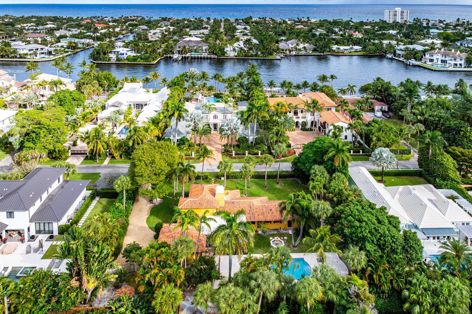 An aerial view shows a yellow house with a tile roof, pool, and lush landscaping — 334 Palm Trail, Delray Beach FL 33483, DELRAY BEACH, FL